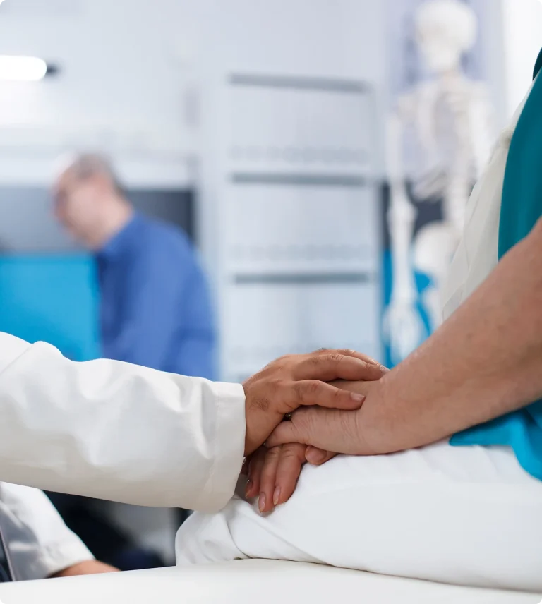 osoby w gabinecie lekarskim trzymające się za ręce